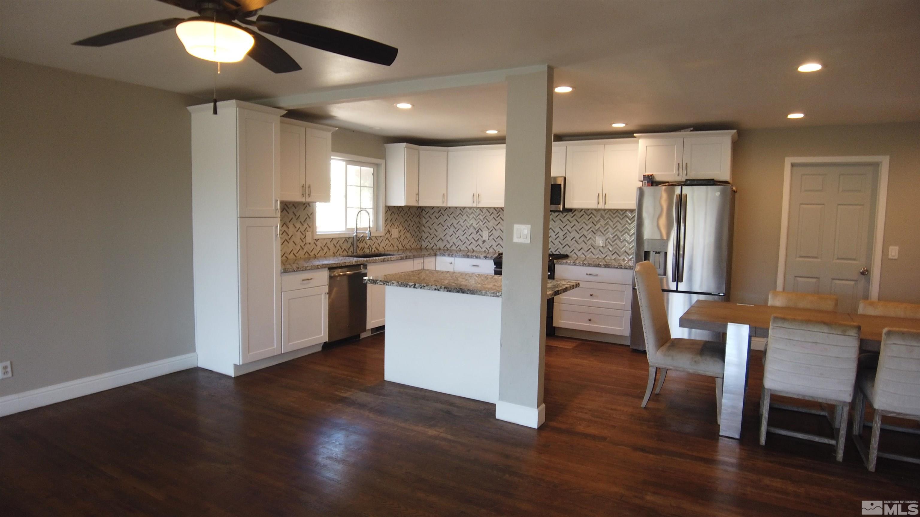 2650 Apollo Way Reno, NV 89503 - Photo 25 of 36 a kitchen with a refrigerator a sink and chairs