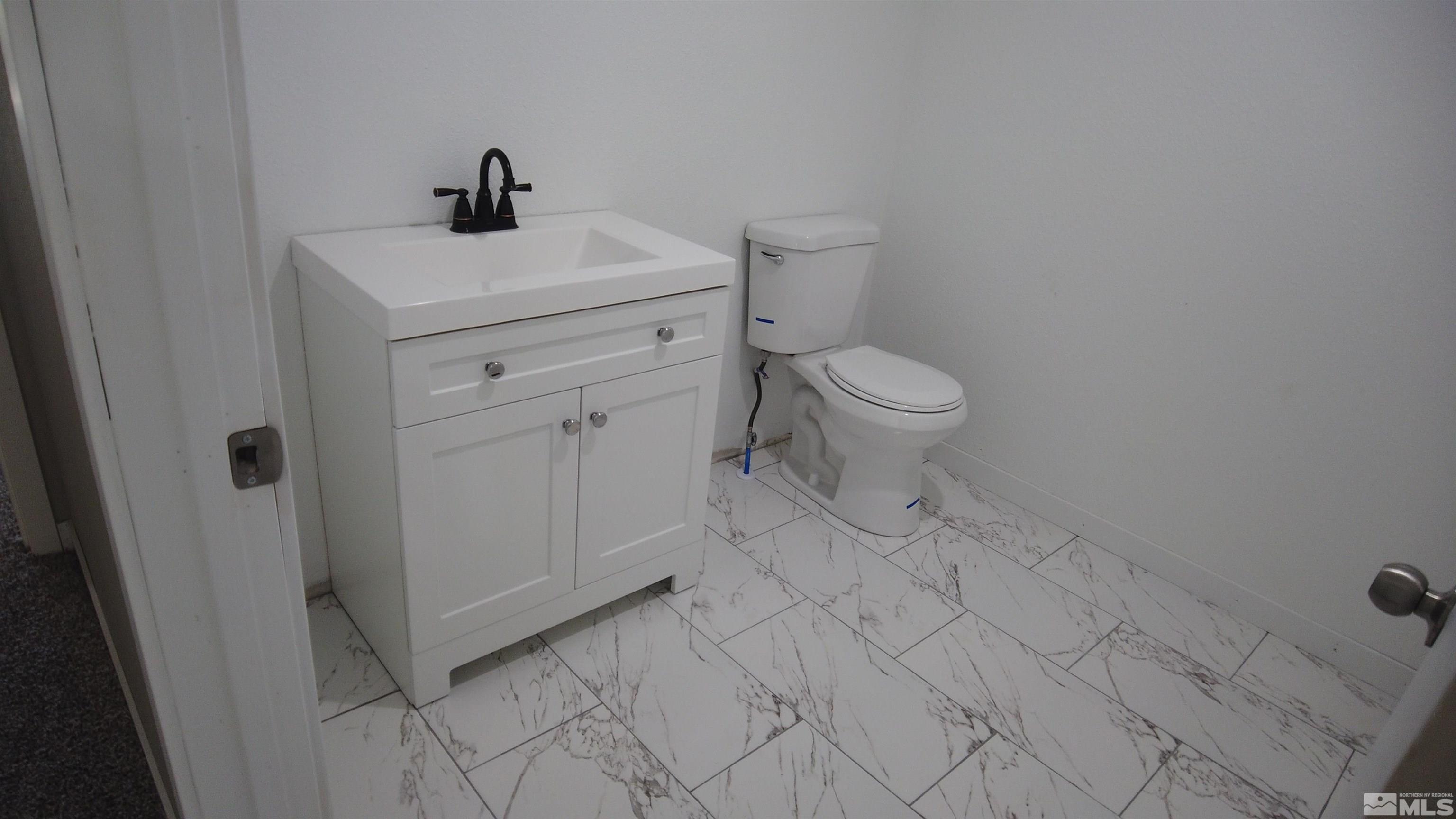 2650 Apollo Way Reno, NV 89503 - Photo 31 of 36 a bathroom with a sink a toilet and a mirror