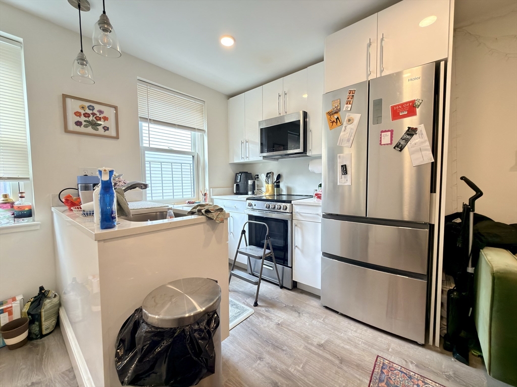 46 Melrose Street, Unit 3 Boston, MA 02116 - Photo 5 of 20 a room with a refrigerator a microwave a sink and wooden floor