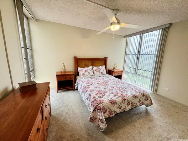 a bedroom with a bed and a dresser next to a window