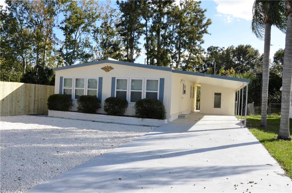 4936 Lake Ridge Lane Holiday, FL 34690 - Photo 1 of 1 a front view of a house with a garden and plants