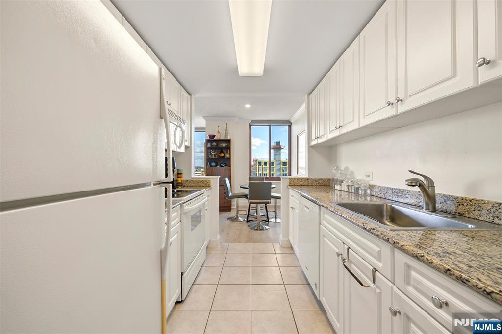 100 Old Palisade Road, Unit 2311 Fort Lee, NJ 07024 - Photo 11 of 25 a kitchen with a sink a refrigerator and cabinets