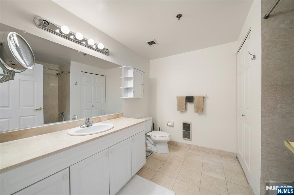 100 Old Palisade Road, Unit 2311 Fort Lee, NJ 07024 - Photo 15 of 25 a bathroom with a sink a toilet and a mirror