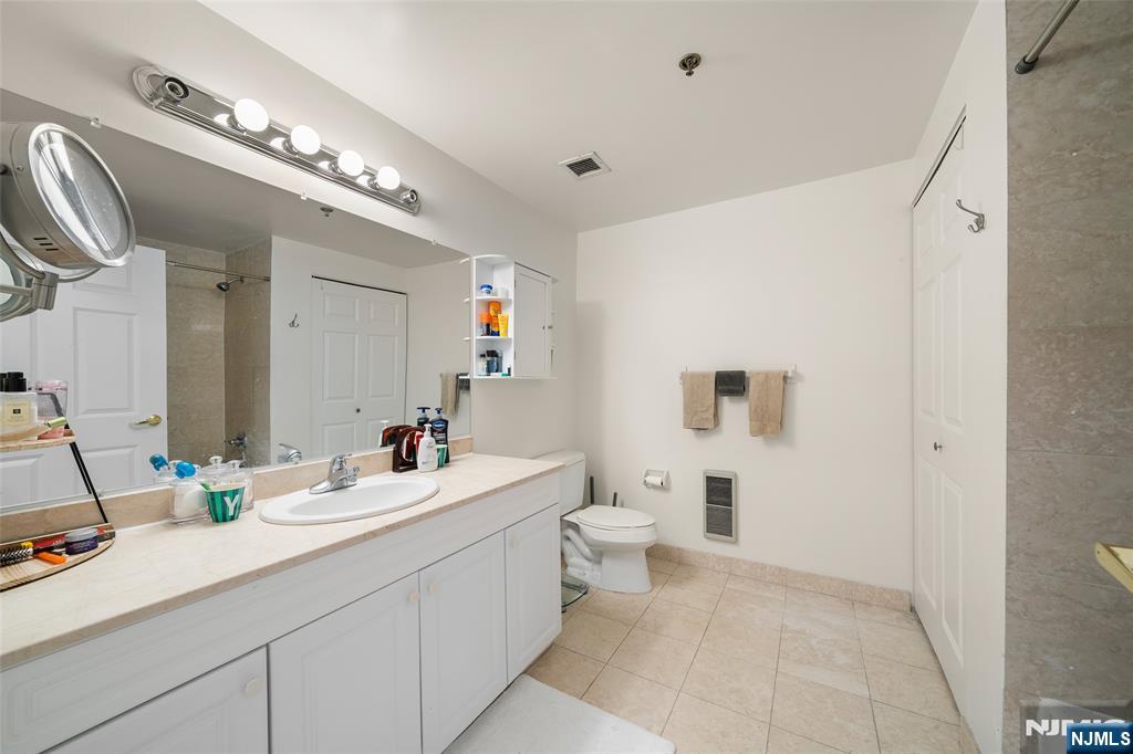100 Old Palisade Road, Unit 2311 Fort Lee, NJ 07024 - Photo 16 of 25 a bathroom with a sink a toilet and a mirror