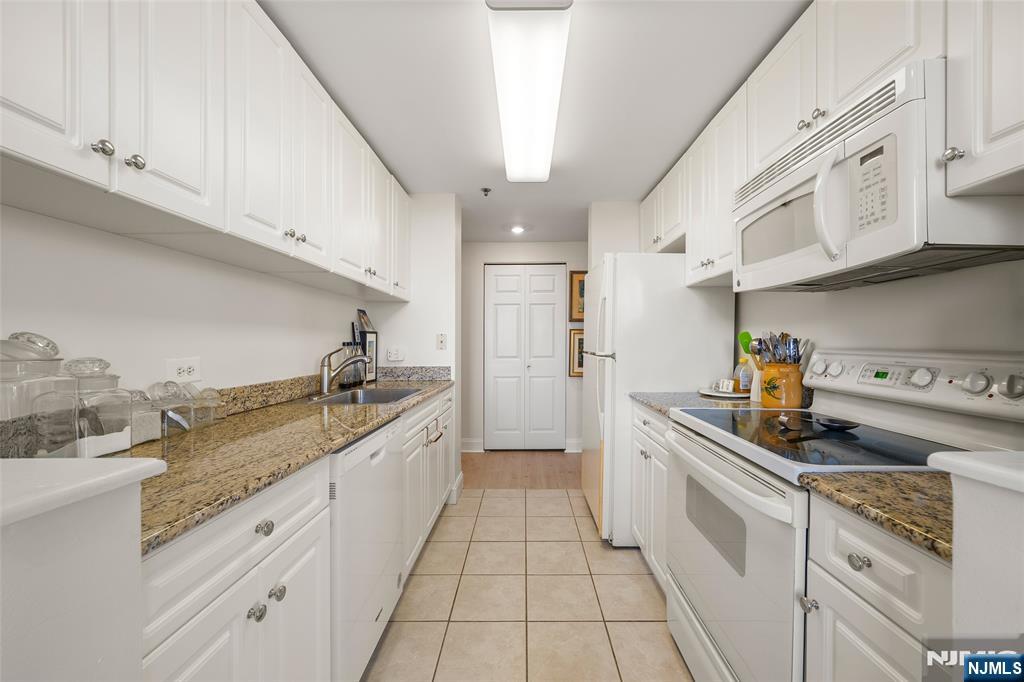 100 Old Palisade Road, Unit 2311 Fort Lee, NJ 07024 - Photo 10 of 25 a kitchen with granite countertop white cabinets and white appliances