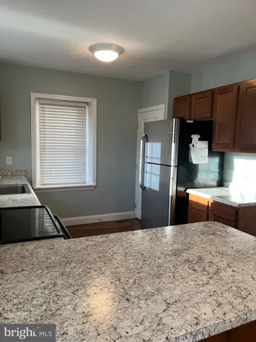 a kitchen with granite countertop a refrigerator and a sink