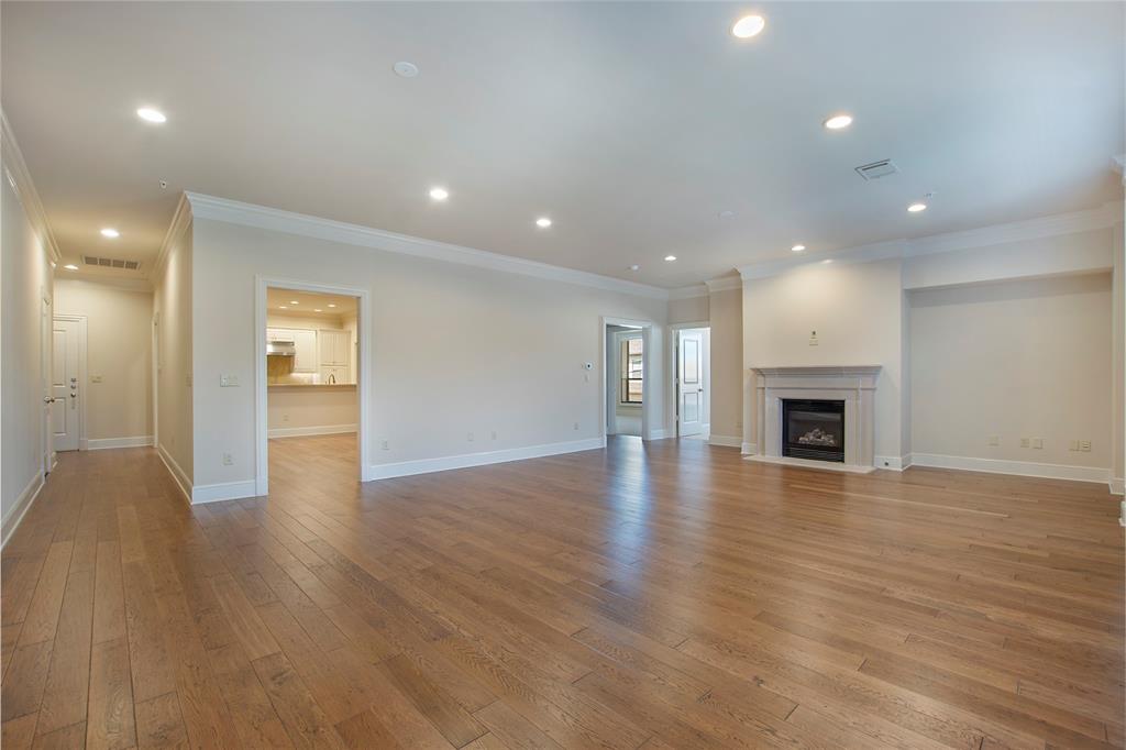 Unfurnished living room featuring ornamental molding and light wood-type flooring