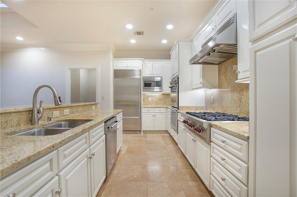6425 Bandera Avenue, Unit 2D Dallas, TX 75225 - Photo 2 of 8 Kitchen with tasteful backsplash, light stone countertops, sink, white cabinetry, and built in appliances