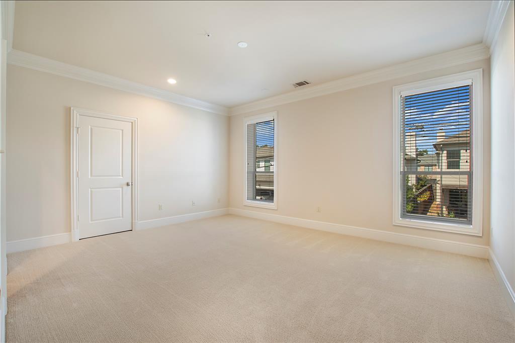 6425 Bandera Avenue, Unit 2D Dallas, TX 75225 - Photo 5 of 8 Empty room with light colored carpet and a healthy amount of sunlight