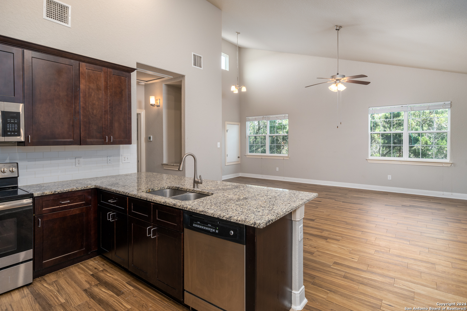 3067 View Ridge Drive, Unit 7 Spring Branch, TX 78070 - Photo 8 of 21 a kitchen with kitchen island granite countertop a sink cabinets and wooden floor