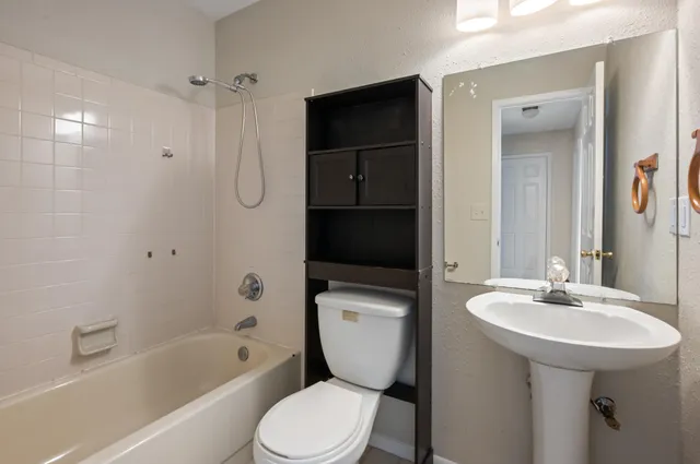 a bathroom with a toilet sink and shower