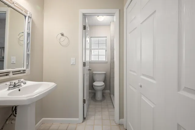 a bathroom with a toilet sink and mirror