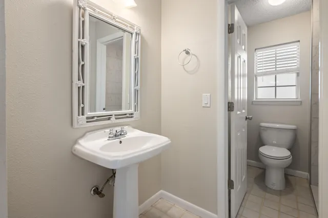 a bathroom with a sink toilet and mirror