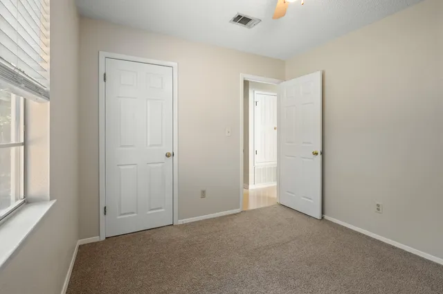 an empty room with windows and closet