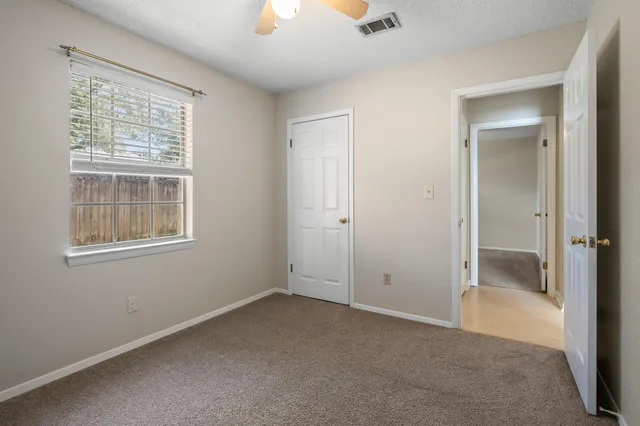 an empty room with windows and closet
