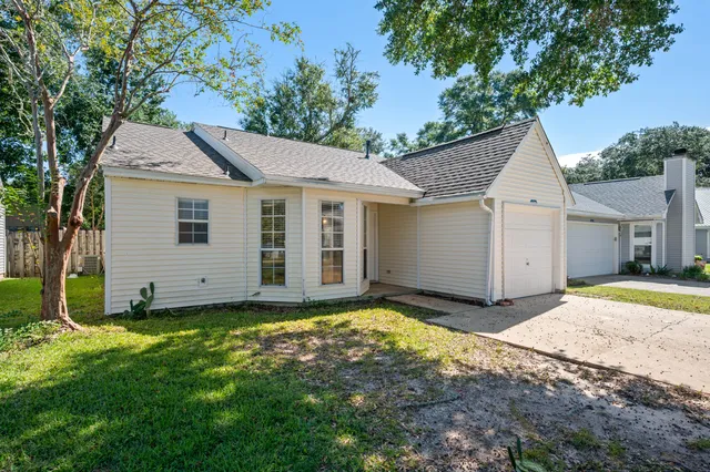 a view of a house with a yard and fence