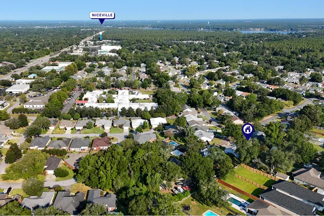 an aerial view of residential houses with outdoor space and trees