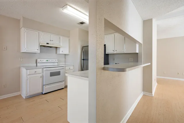 a kitchen with white cabinets and white appliances