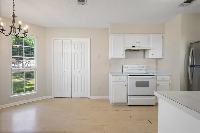a kitchen with white cabinets and white appliances