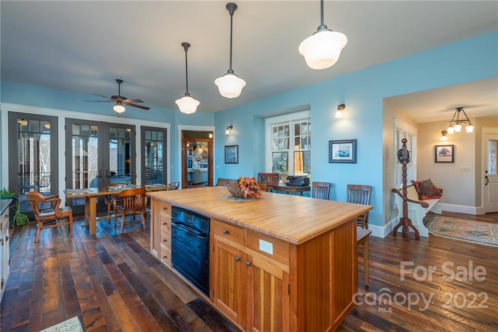 1116 Glades Road Clyde, NC 28721 - Photo 12 of 48 a view of kitchen island a dining table chairs and wooden floor