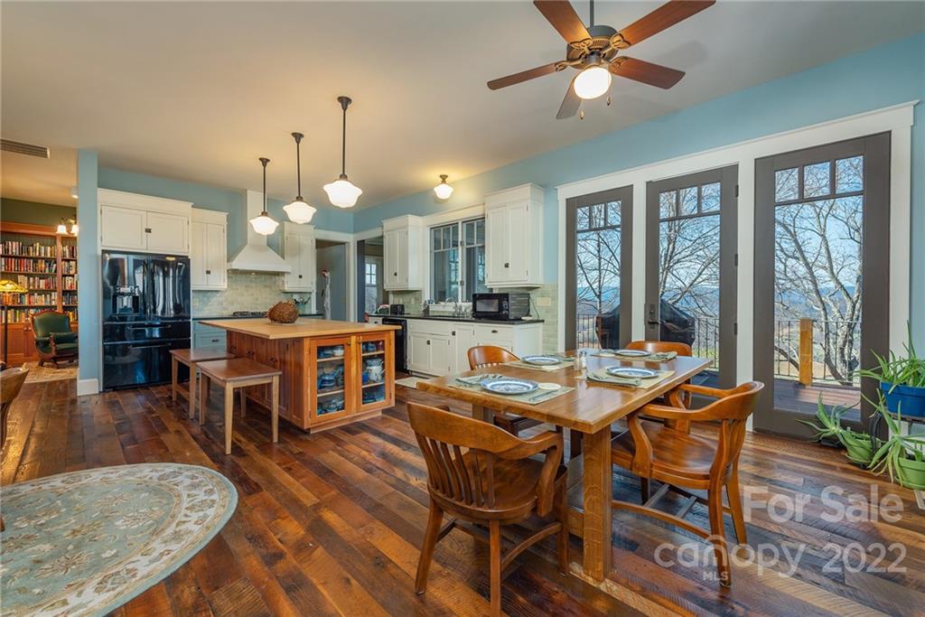 1116 Glades Road Clyde, NC 28721 - Photo 14 of 48 a dining room with wooden floor a chandelier a wooden table and chairs