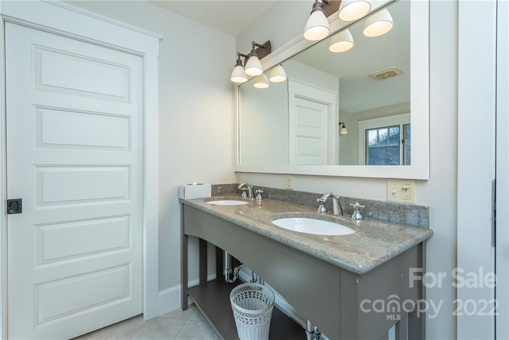 1116 Glades Road Clyde, NC 28721 - Photo 24 of 48 a bathroom with a granite countertop sink and a mirror