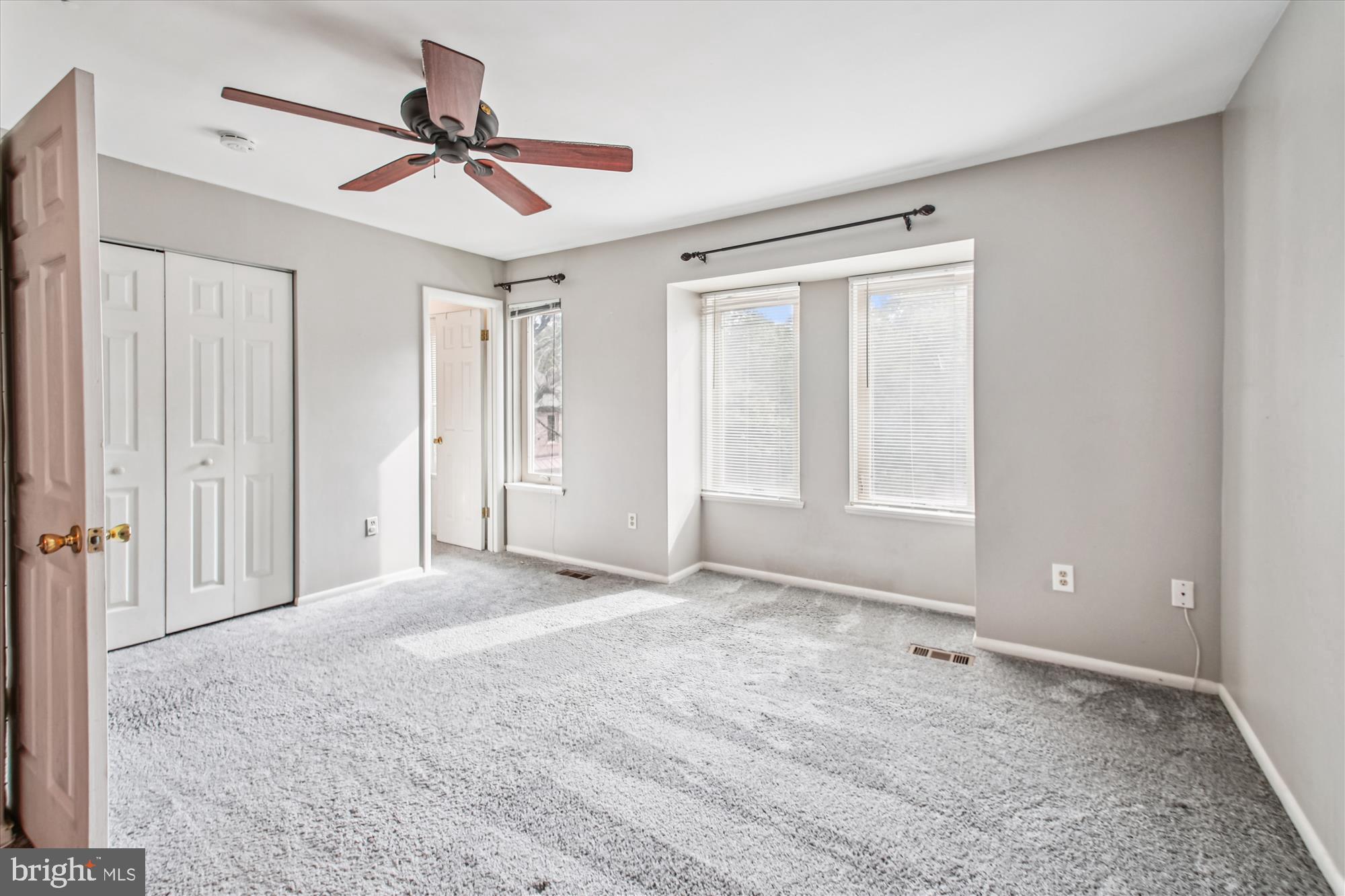 9469 Clocktower Lane Columbia, MD 21046 - Photo 14 of 28 a view of a livingroom with a ceiling fan & windows