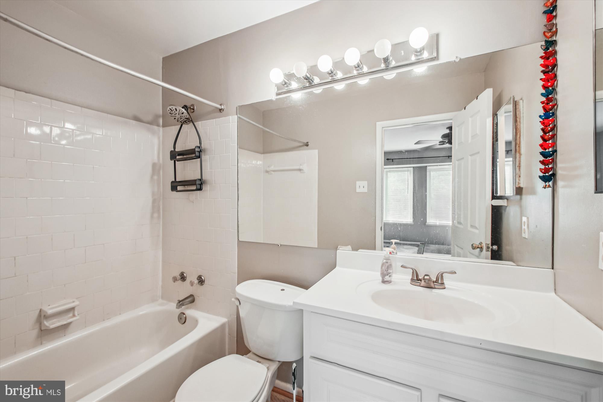 9469 Clocktower Lane Columbia, MD 21046 - Photo 26 of 28 a bathroom with a sink mirror vanity toilet and bathtub