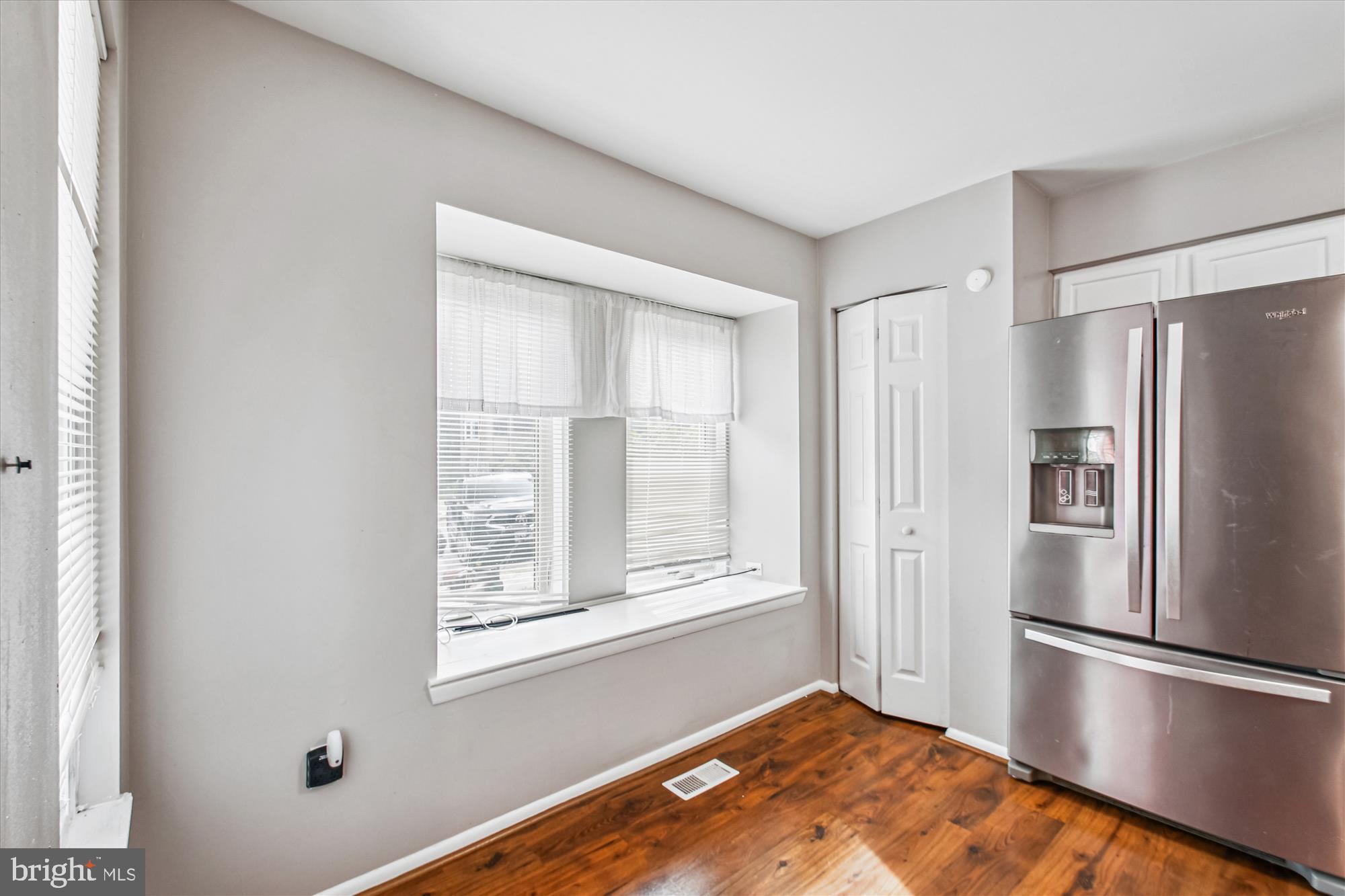 9469 Clocktower Lane Columbia, MD 21046 - Photo 6 of 28 a view of a kitchen with wooden floor and a refrigerator