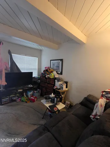 a living room with furniture a flat screen tv and a window