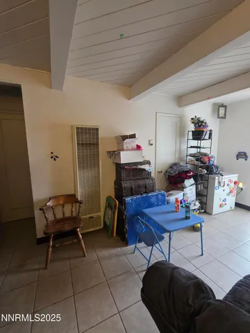 a living room with furniture and a dining table with kitchen appliances