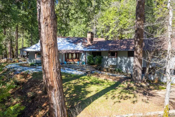 a view of a house with backyard and sitting area