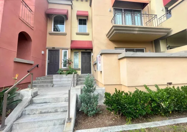 a view of a house with large windows and plants
