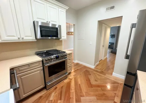 a kitchen with stainless steel appliances a stove microwave and sink
