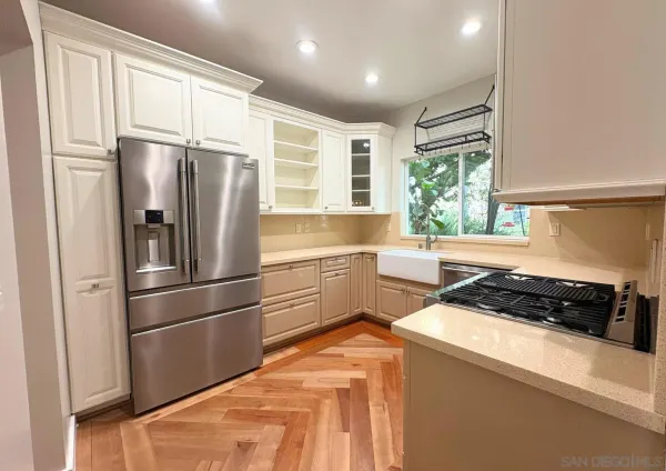 a kitchen with a refrigerator a sink and white cabinets