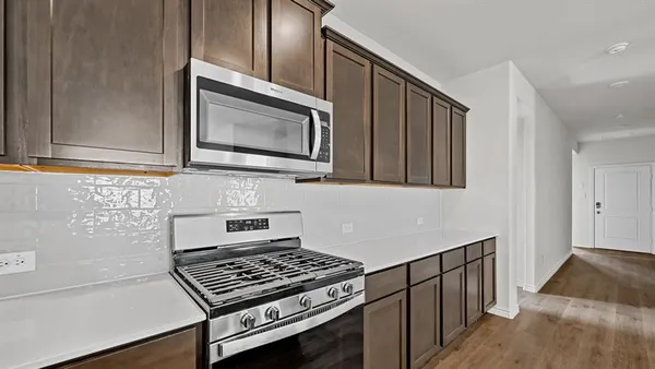 a large white kitchen with kitchen island a sink appliances and cabinets