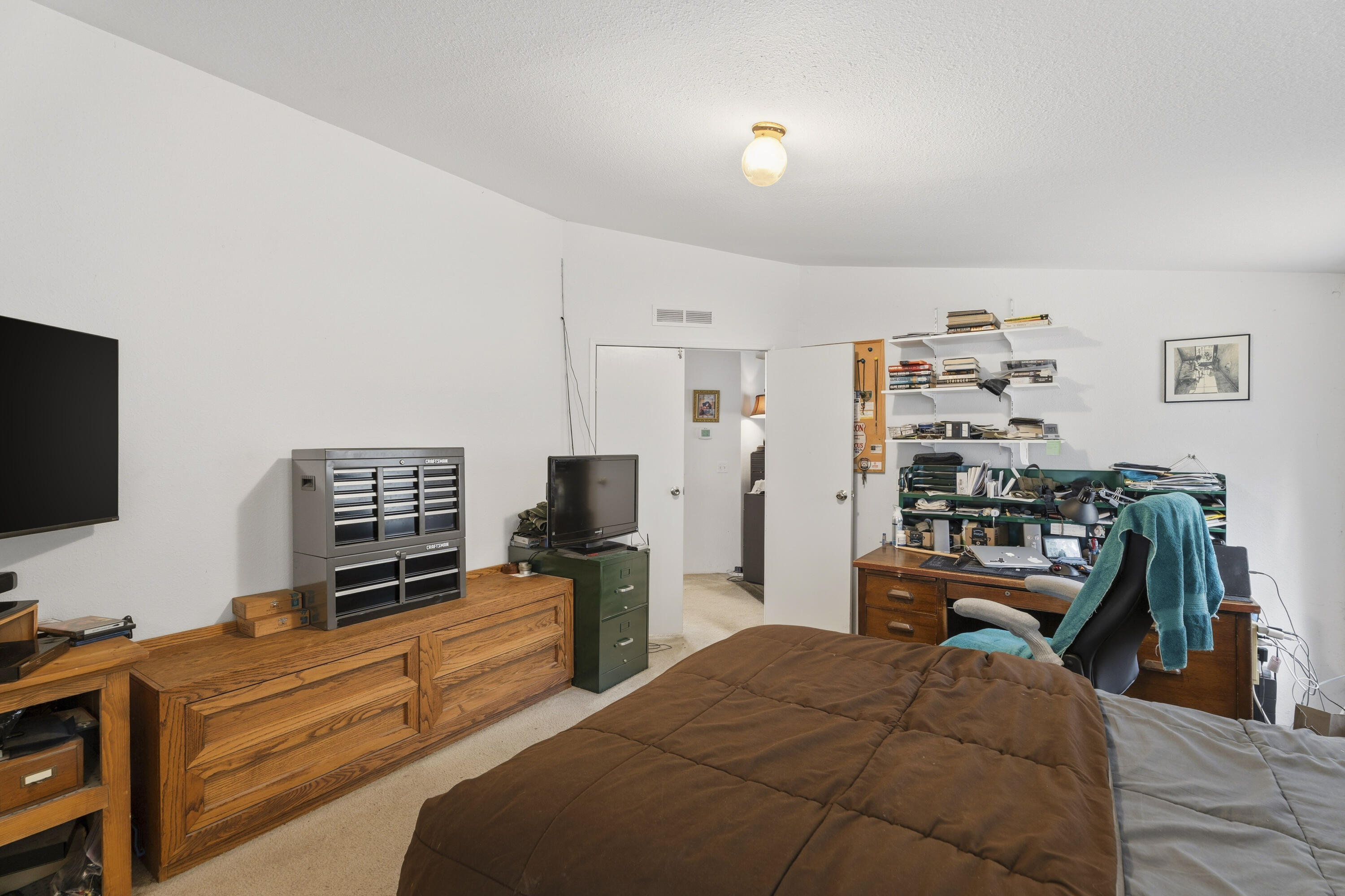 16928 Covina Road Bend, OR 97707 - Photo 24 of 48 a bedroom with a bed and a flat screen tv