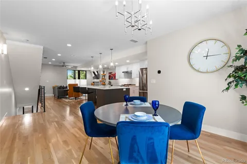 a dining room with furniture a chandelier and wooden floor