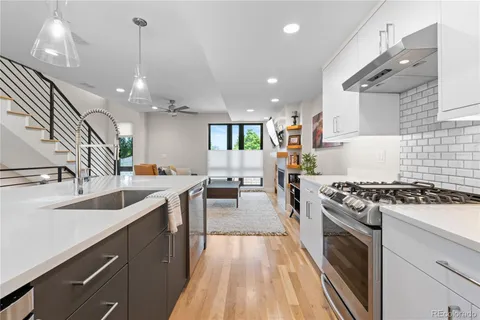 a kitchen with granite countertop a sink stove and cabinets