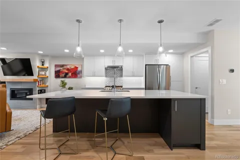 a kitchen with stainless steel appliances kitchen island granite countertop a table chairs sink and cabinets