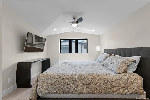 a bedroom with a large bed and a flat screen tv