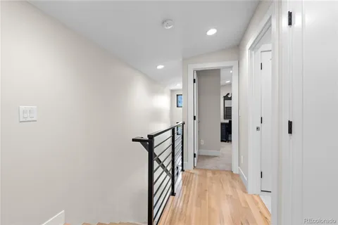 a view of a hallway with wooden floor and staircase