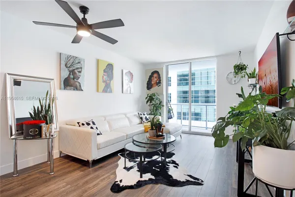 a living room with furniture potted plant and a flat screen tv