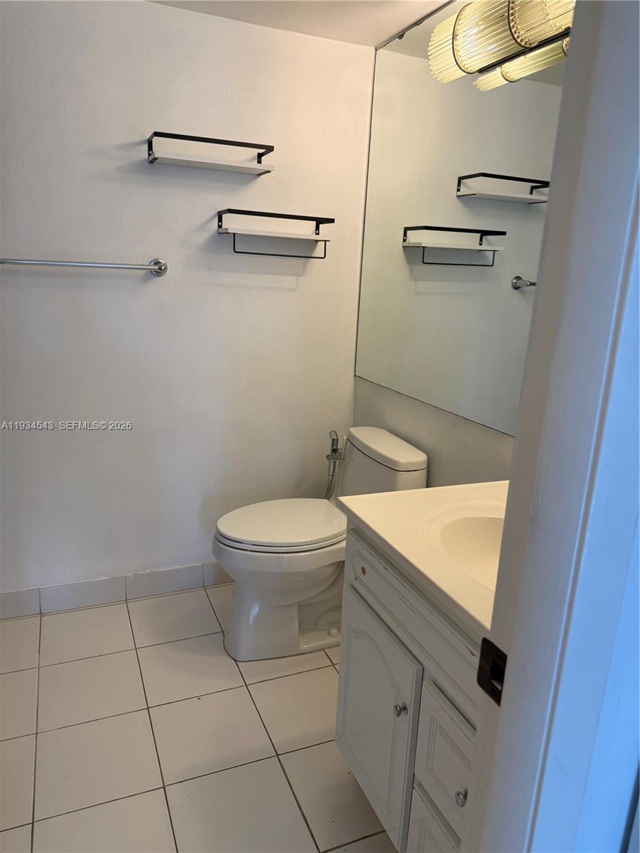 5199 Northwest 7th Street, Unit 115 Miami, FL 33126 - Photo 11 of 14 a bathroom with a toilet a sink and mirror