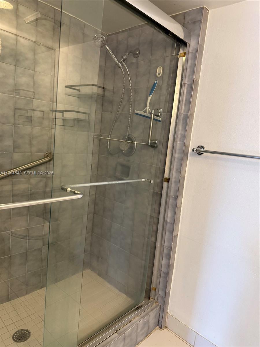 5199 Northwest 7th Street, Unit 115 Miami, FL 33126 - Photo 13 of 15 a bathroom with a glass shower door
