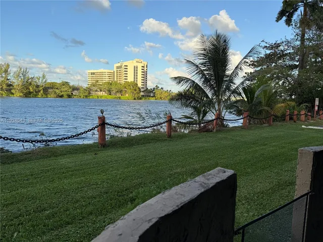 a view of a house with a big yard and a large tree