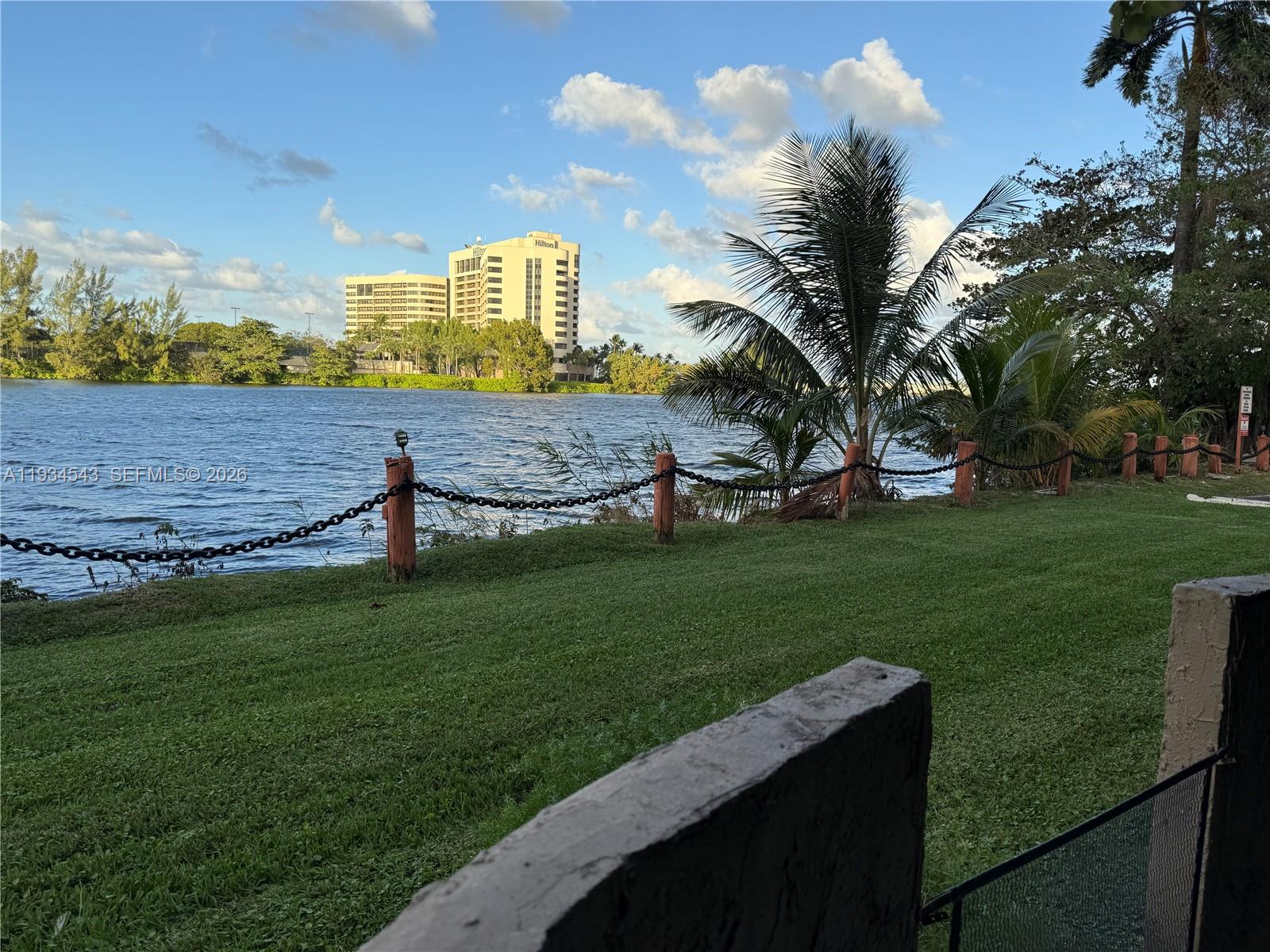 5199 Northwest 7th Street, Unit 115 Miami, FL 33126 - Photo 2 of 14 a view of a house with a big yard and a large tree