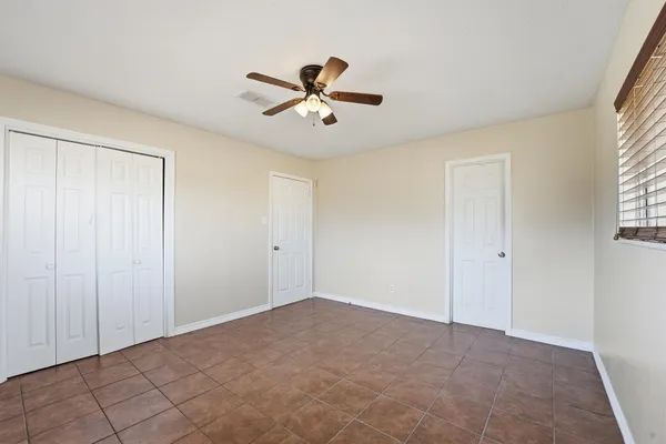 a view of a room with a ceiling fan and a window