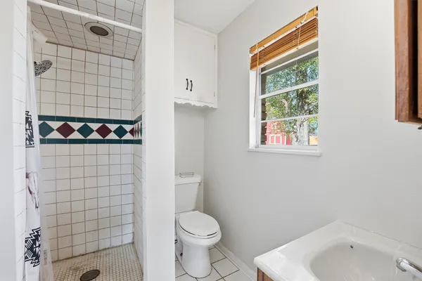 a bathroom with a toilet and shower curtain