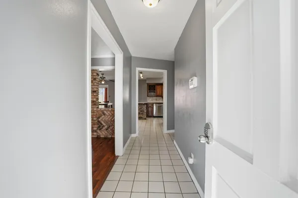 a view of a hallway with wooden floor and staircase